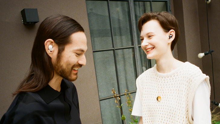 Um homem e uma mulher os fones Galaxy Buds
