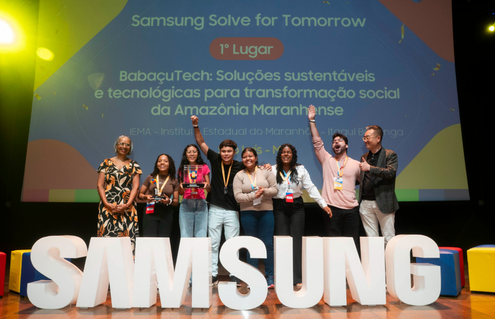Alunos, professores e representantes da Samsung posam para foto em frente ao letreiro da marca