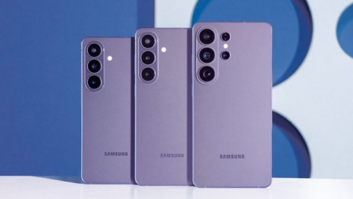 A imagem mostra três smartphones da linha Galaxy S26, enfileirados um ao lado do outro, na cor lilás. Eles estão sobre uma superfície branca, e a imagem ao fundo é em um tom azul com detalhes em branco.