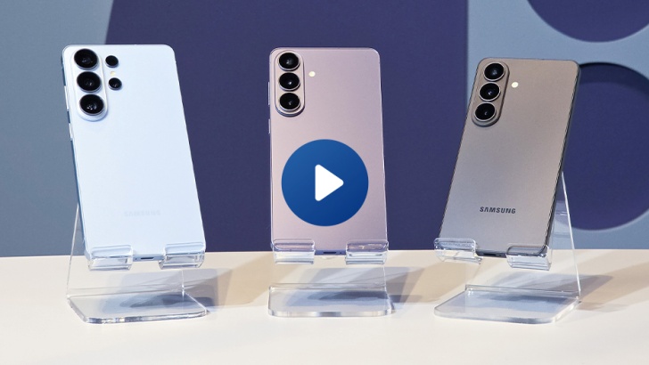 Três celulares da linha Galaxy S26 - um branco, outro lilás e outro preto -, um ao lado do outro, apoiados sobre uma mesa.
