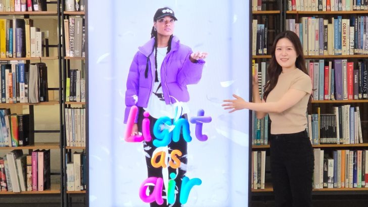 Yujin Nam ao lado de uma Spatial Signage