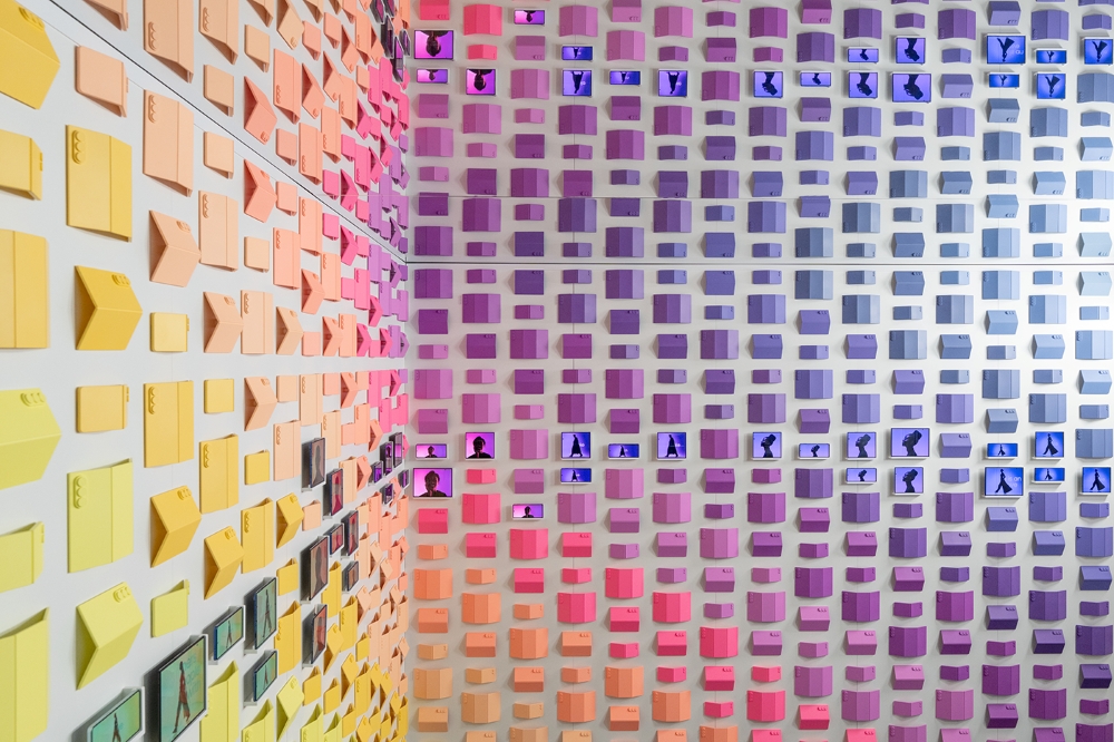 A imagem mostra um dos cenários da exposição 'Design is an act os Love" com um espectro colorido composto por dispositivos dobráveis da Samsung.