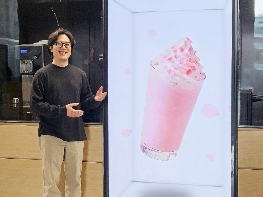Jong-Gu Su sorri ao lado do Spatial Signage da Samsung