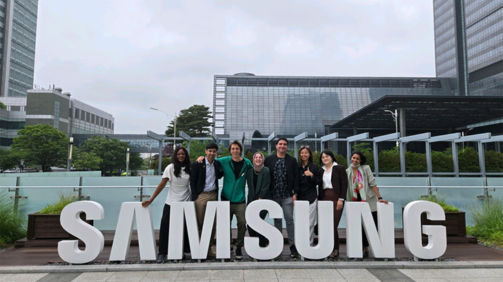 Membros do Generation17 posam juntos para foto em frente ao letreiro da Samsung, na Coreia.