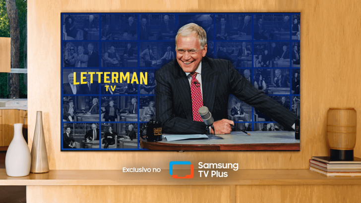 magem mostra cena do programa Letterman TV, um dos maiores nomes da televisão americana, David Letterman, em uma TV da Samsung ambientada em um painel de madeira claro e decoração com vasos e luminária na cor bege.