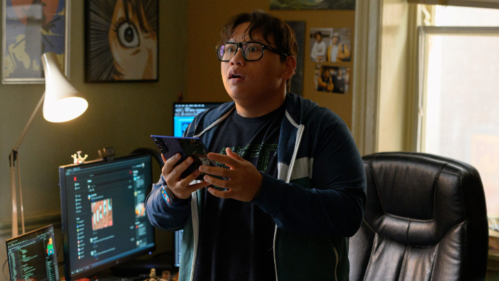 Ned Leeds, interpretado por Jacob Batalon, aparece com uma expressão de surpresa enquanto tenta localizar o Homem-Aranha usando o Spidey Tracker em um celular Samsung Galaxy Z Fold7 em cena do filme Homem-Aranha: Um Novo Dia.