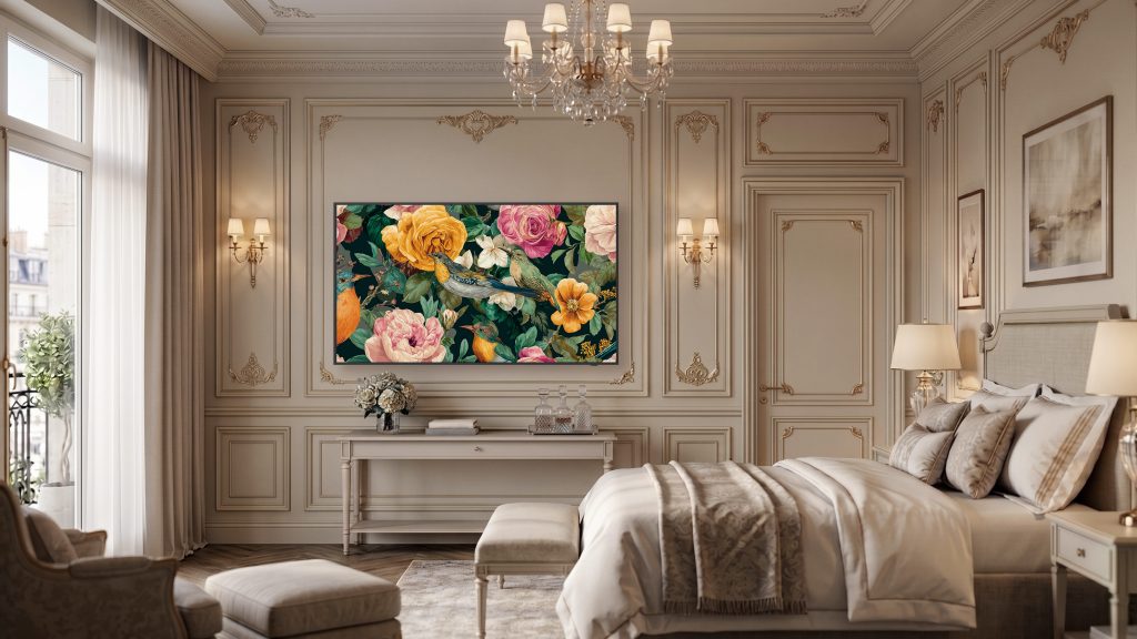 Instalada em uma suíte de hotel premium, a Samsung The Frame para hotéis exibe uma obra artística com flores e pássaros em cores vibrantes. Integrada harmoniosamente ao ambiente, a tela funciona como uma peça de arte digital, complementando a decoração clássica do quarto. O espaço conta com detalhes ornamentais, iluminação aconchegante e mobiliário refinado, destacando a proposta da The Frame de unir tecnologia e design para o setor de hospitalidade.
