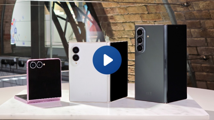 Da esquerda para à direita, a imagem mostra os três celulares Samsung Galaxy Z Flip8 (na cor rosa), Galaxy Z Fold8 (branco) e Galaxy Z Fold8 (preto). Eles estão em cima de uma superfície branca e, ao fundo, uma parede de tijolos ao lado de uma janela. Os três dispositivos aparecem semi-abertos, mostrando a parte traseira das câmeras.
