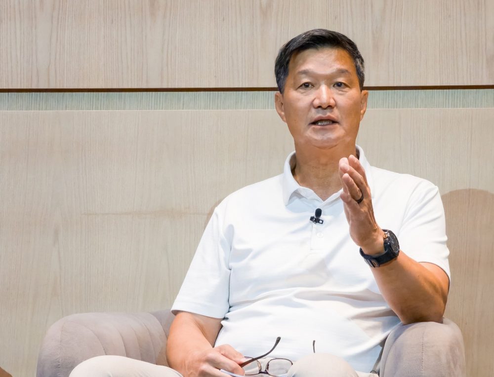Dr. Hon Pak, vice-presidente sênior e líder da equipe de Saúde Digital da Samsung Electronics, fala ao público durante o painel, sentado em uma poltrona e gesticulando com uma das mãos.