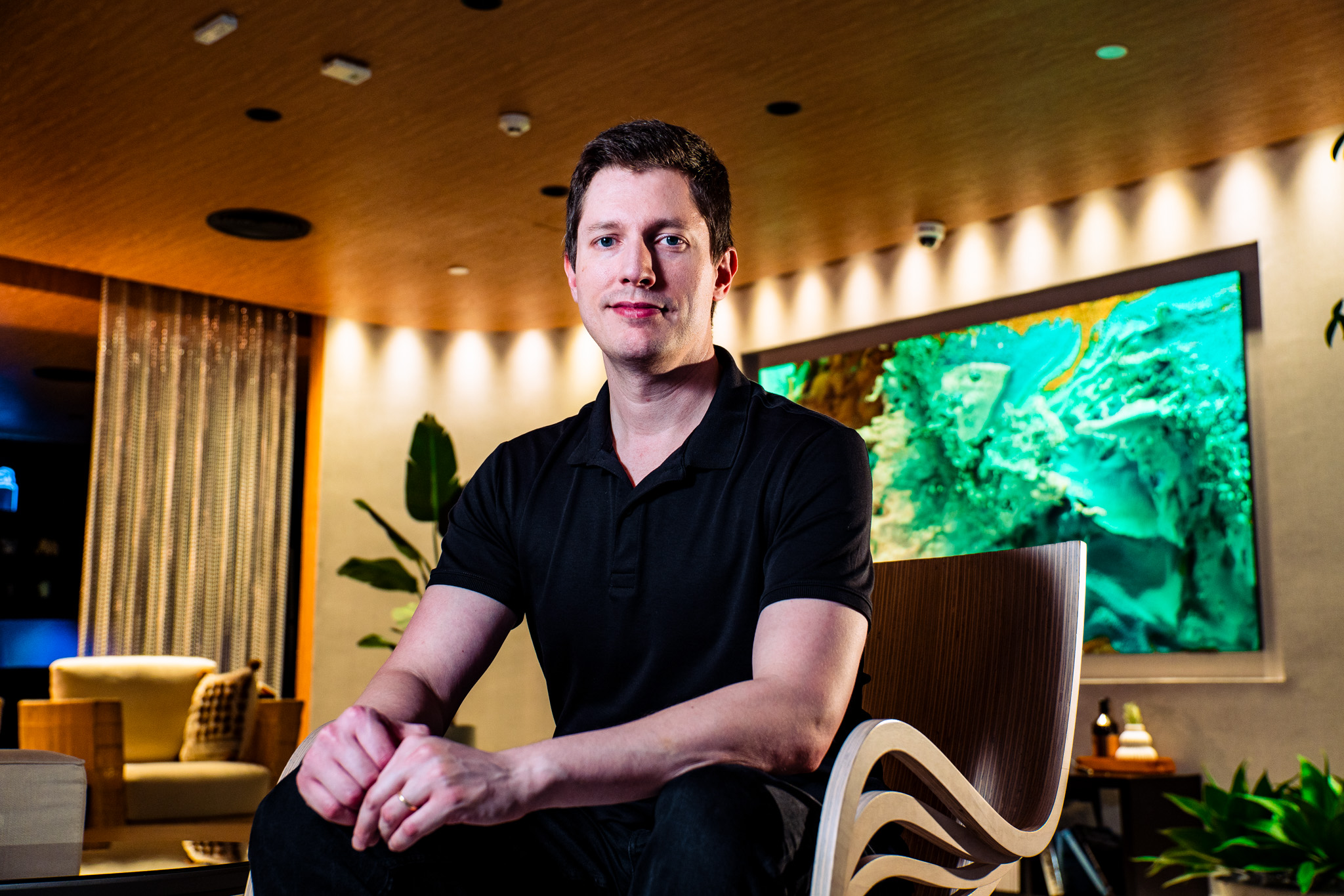 Alexandre Gleb, gerente de TVs da Samsung, sentado em uma poltrona em ambiente com uma TV Samsung ao fundo.