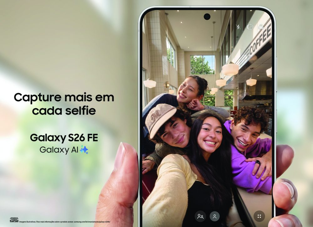 Galaxy S26 FE sendo segurado na vertical, com a câmera frontal enquadrando quatro pessoas em um café.