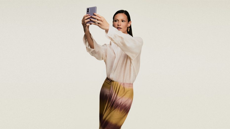 Modelo veste look da coleção ÁGUA DE COCO inspirada no Galaxy Z Fold8 e segura um Galaxy Z Fold8 na cor lavanda enquanto faz uma selfie.
