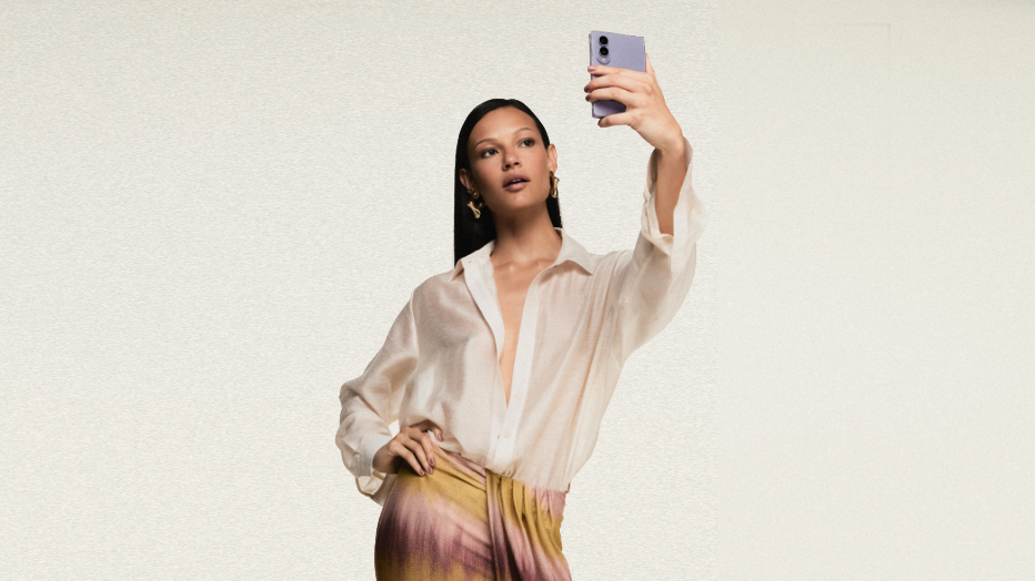 Modelo veste look da coleção ÁGUA DE COCO inspirada no Galaxy Z Fold8 e segura um Galaxy Z Fold8 na cor lavanda enquanto faz uma selfie.
