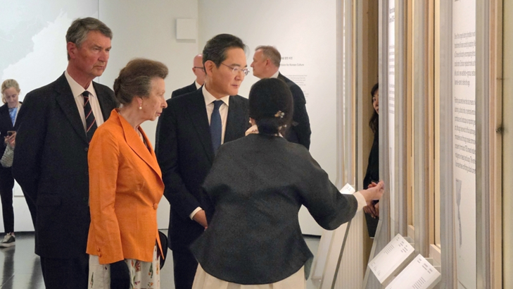 Mulher apresenta a um grupo de visitantes elemento de uma exposição no Museu Britânico