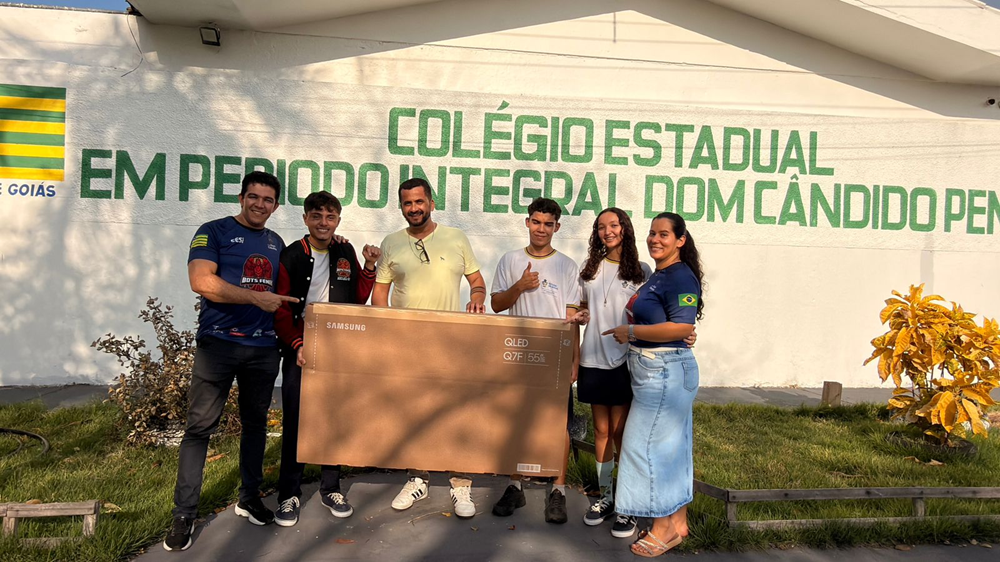 Alunos e professores posam juntos com uma TV Samsung em frente a colégio estadual em Goiás