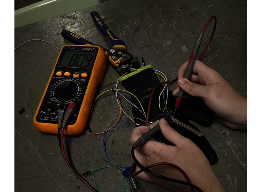 A imagem mostra um equipamento eletrônico sendo montado pelas mãos de um adolescente do sexo masculino