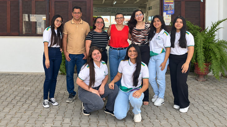 Equipe de alunas e professores posam juntos em frente à escola pública em Fortaleza (CE)