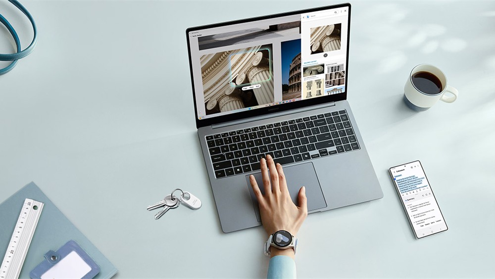 Person arbeitet an einem Laptop, auf dem architektonische Fotos angezeigt werden. Neben dem Laptop liegen Schlüssel mit einem Schlüsselanhänger