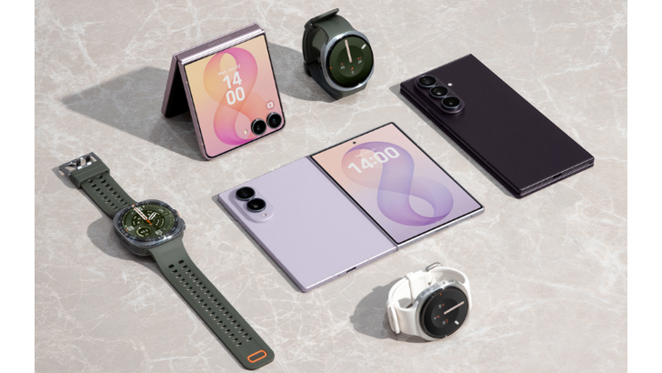 Sieben Samsung Galaxy Geräte liegen auf einer hellen Marmoroberfläche: zwei Falt-Smartphones, drei Smartwatches und ein Smartphone in Dunkelviolett.