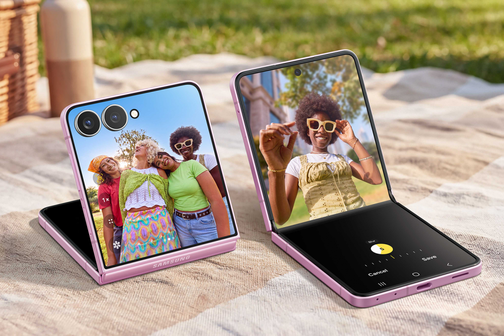 Dos Samsung Galaxy Z Flip8 rosas en modo FlexCam muestran la captura de fotos grupales y el ajuste del desenfoque en un entorno de pícnic.