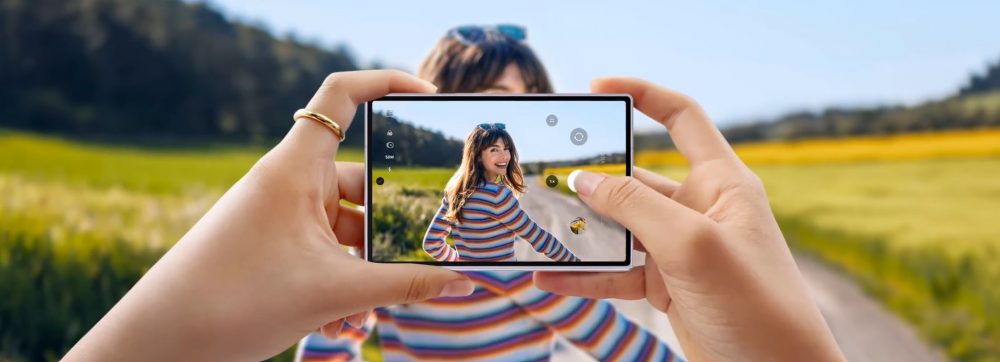 Samsung Galaxy Z Fold8 used in landscape orientation to photograph a person outdoors, with the camera preview visible on the large display.