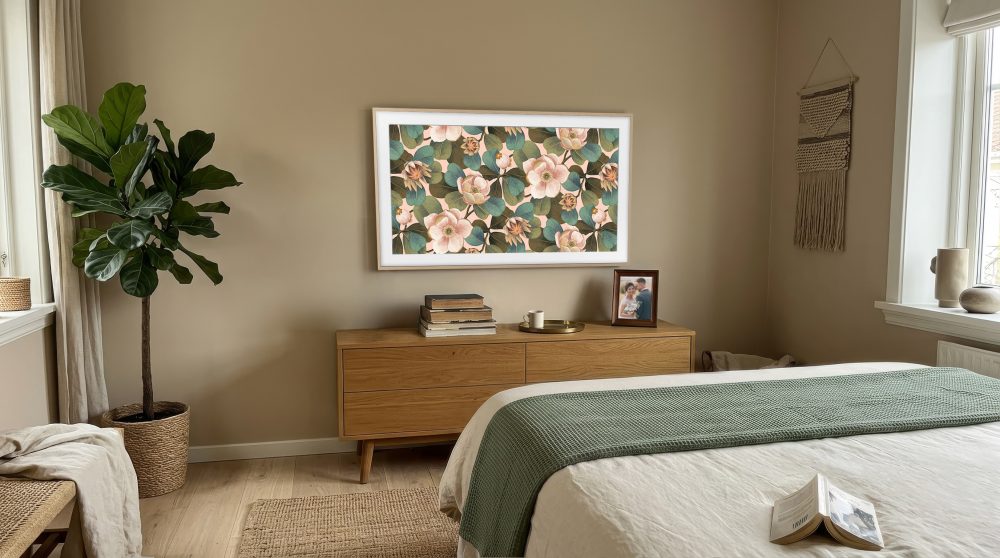 The Frame integrado en un dormitorio, mostrando una obra floral en pantalla sobre una cómoda de madera y como parte de la decoración de la estancia.