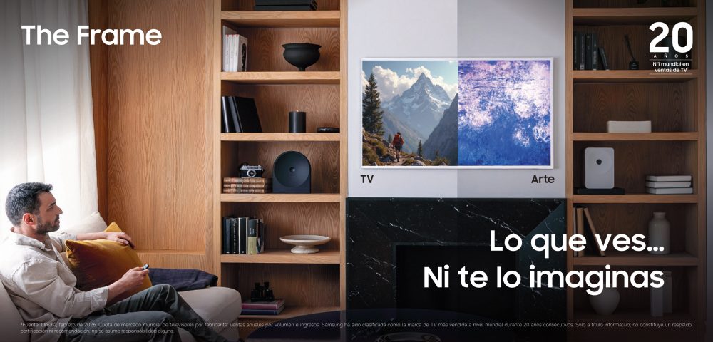 Hombre sentado en un salón frente a The Frame, integrado en una estantería de madera, mostrando en pantalla la transición entre contenido de TV y una obra de arte.