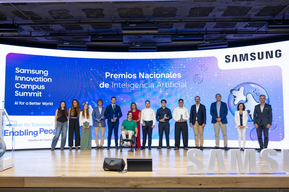 Foto de grupo en el escenario del Samsung Innovation Campus Summit durante los Premios Nacionales de Inteligencia Artificial, con participantes y premiados posando frente a la pantalla del evento.