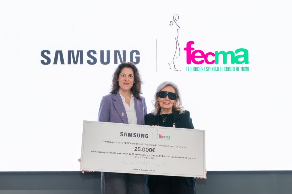 Dos representantes de Samsung y FECMA (Federación Española de Cáncer de Mama) posan con un cheque solidario de 25.000 euros, recaudados mediante la aportación de 50 euros por cada Samsung Galaxy Z Flip8 rosa vendido durante la campaña contra el cáncer de mama.