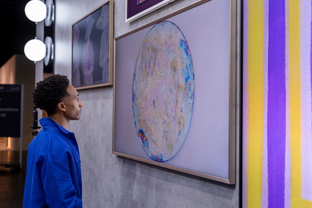 Un visiteur découvre l’œuvre de Raphael Hefti exposée sur les TV Art Samsung .
