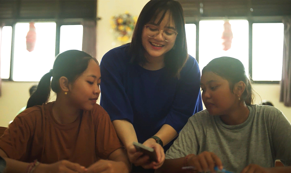 Brigitta teaches students about underwater ecosystems using a Samsung Galaxy phone.