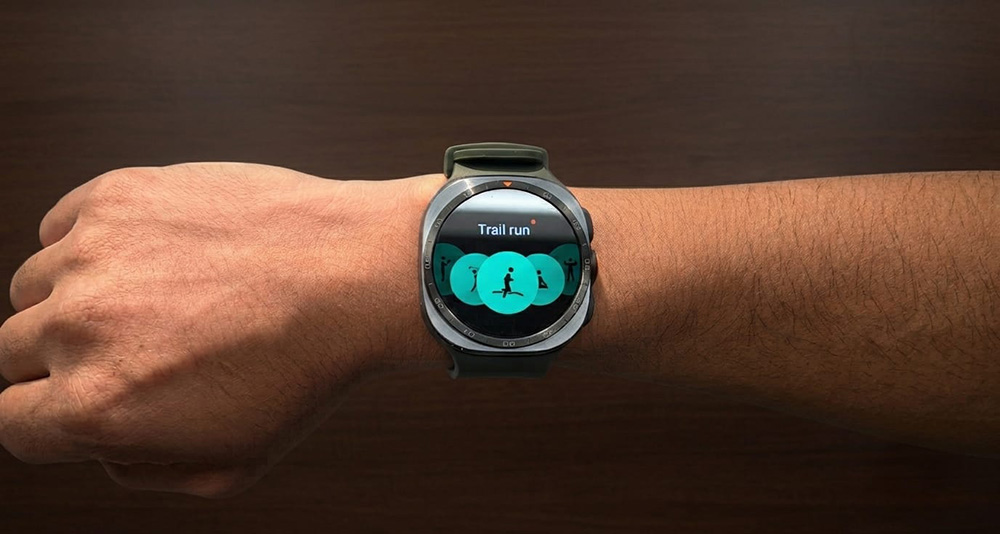 Galaxy Watch Ultra2 dikenakan di pergelangan tangan seseorang yang sedang beraktivitas di luar ruangan, menampilkan desain kokoh dengan layar jam yang menyala.