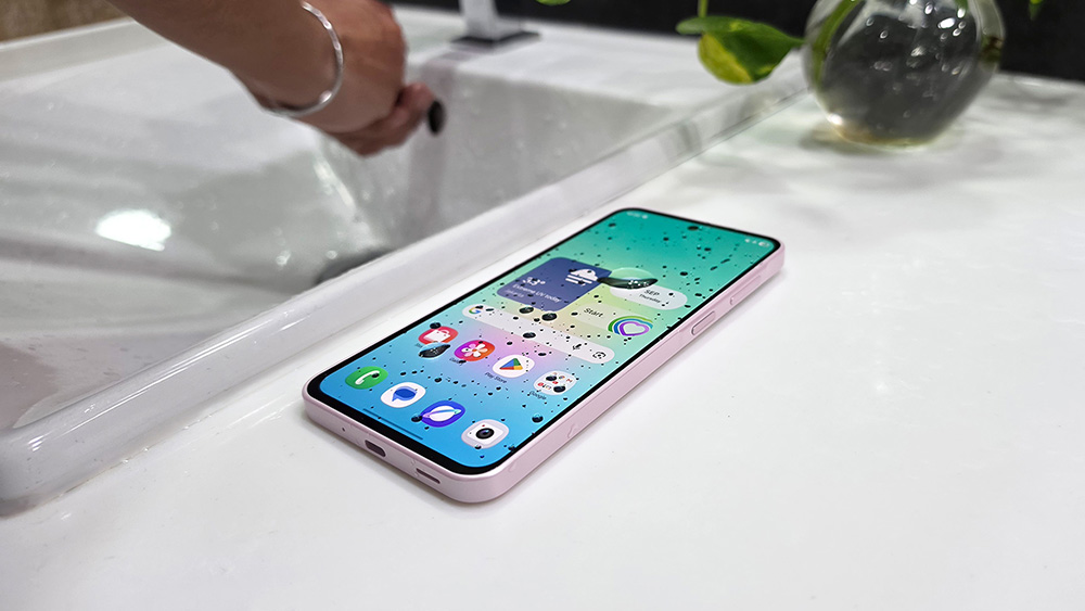Samsung Galaxy A27 5G warna pink diletakkan di dekat wastafel dengan perlindungan IP64